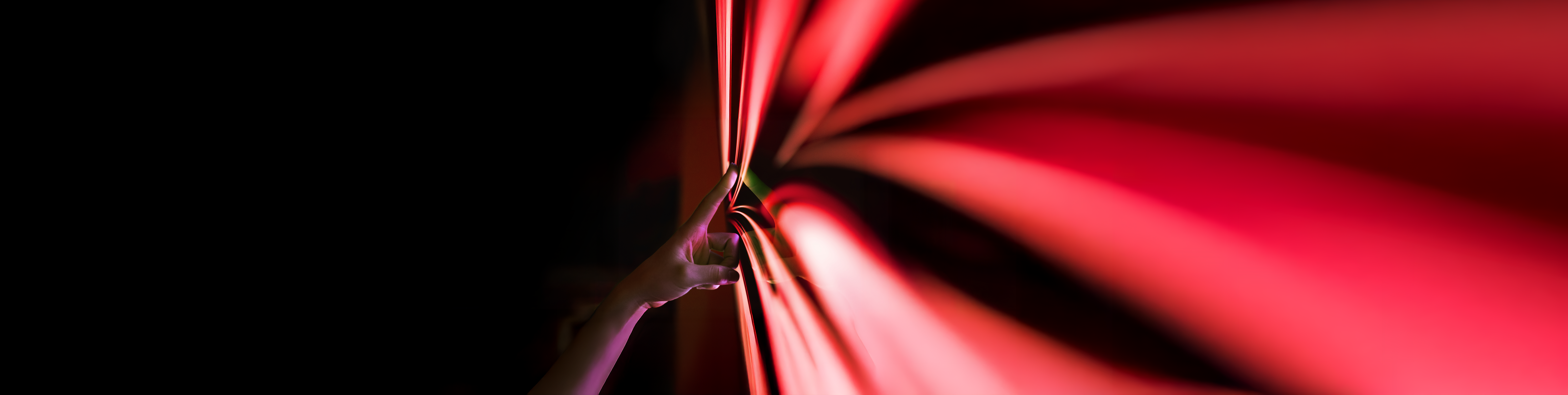 A hand touching PHINIA's red arrow logo