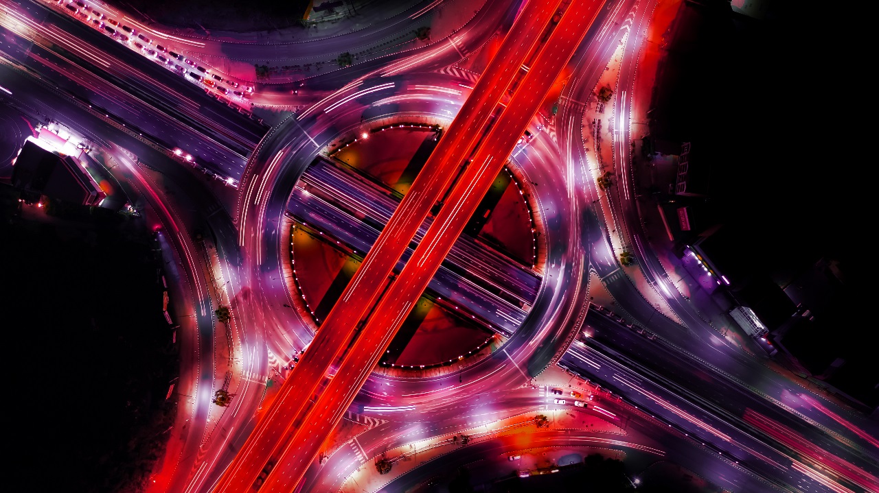 An aerial view of a roundabout lit up with red lights