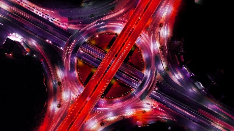 An aerial view of a roundabout lit up with red lights