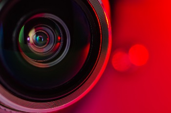 A close up of a camera lens with a red background