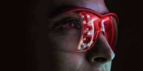 A person wearing red future-looking glasses