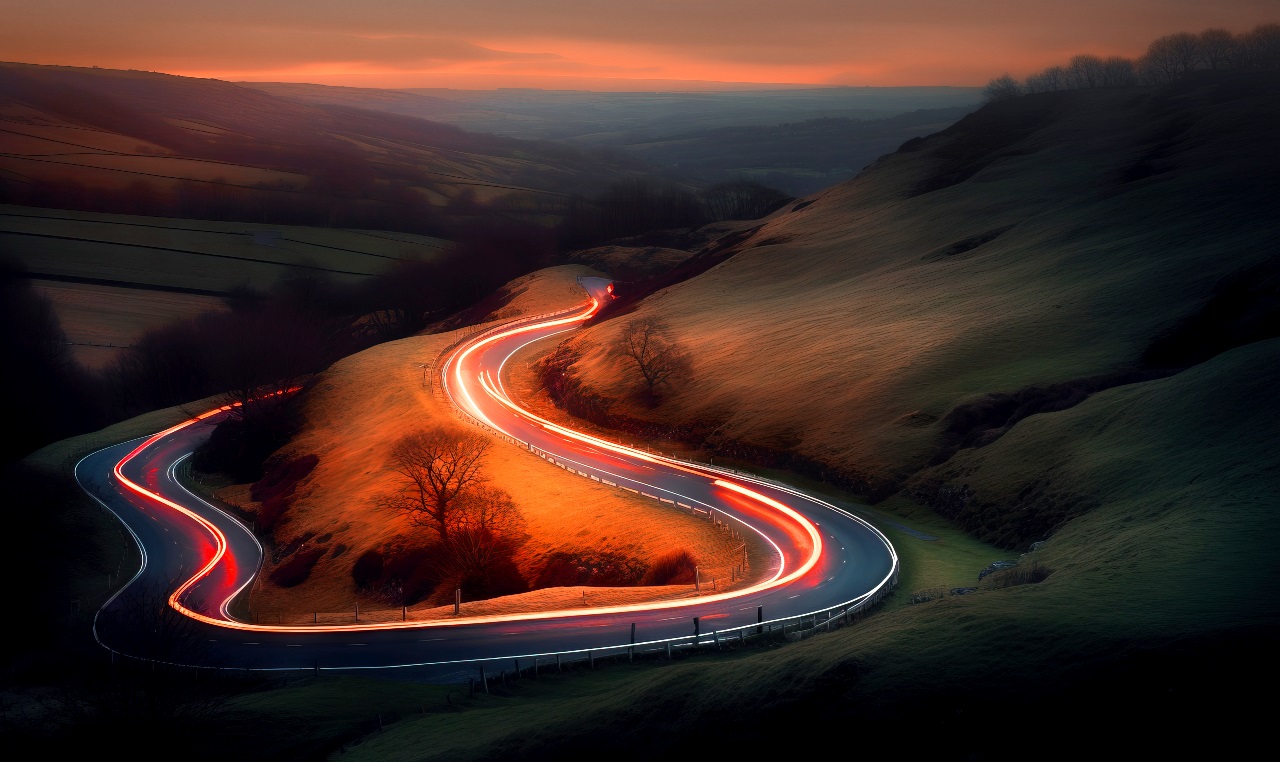 A winding road with lights going toward the future