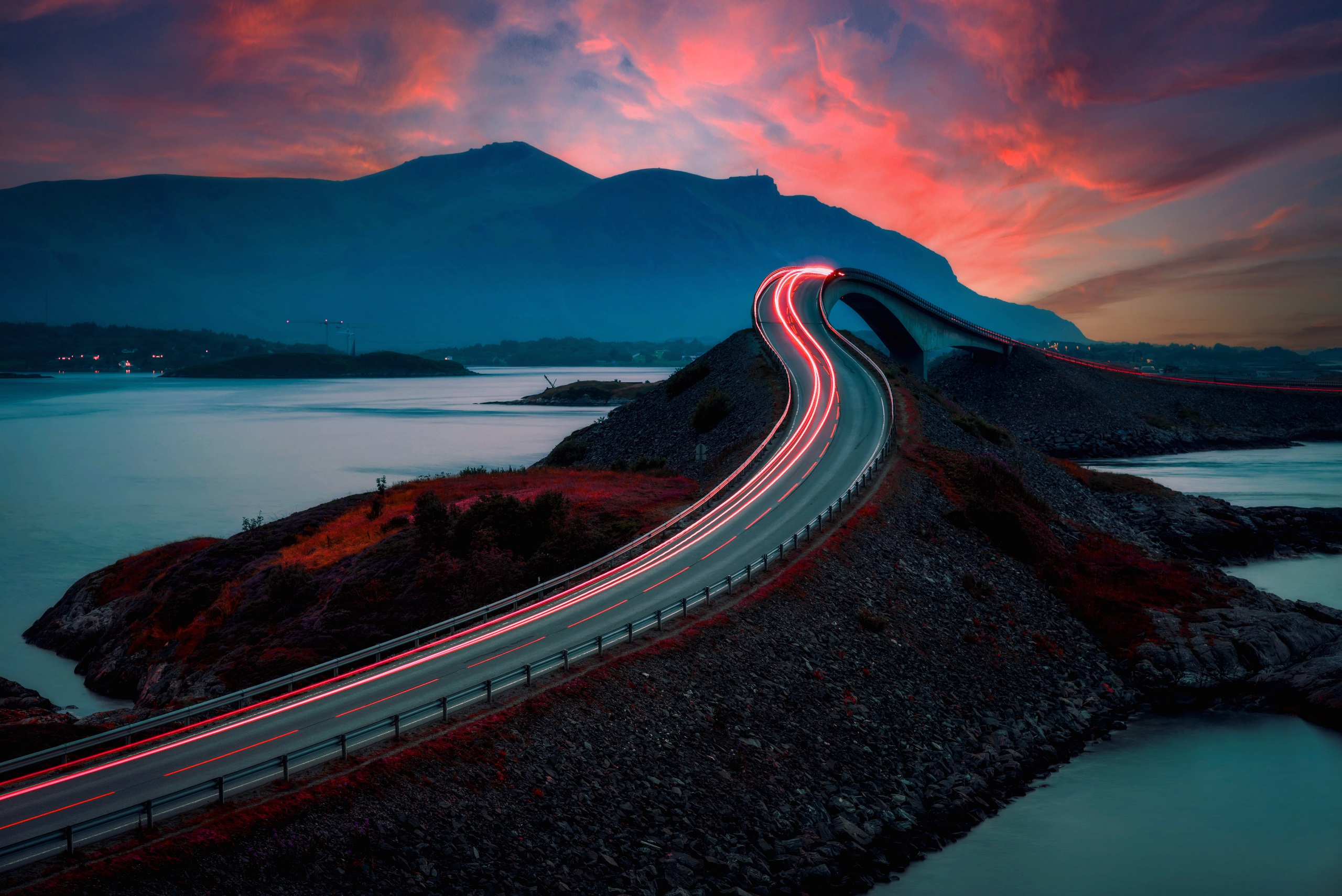 A winding road with lights going toward the future