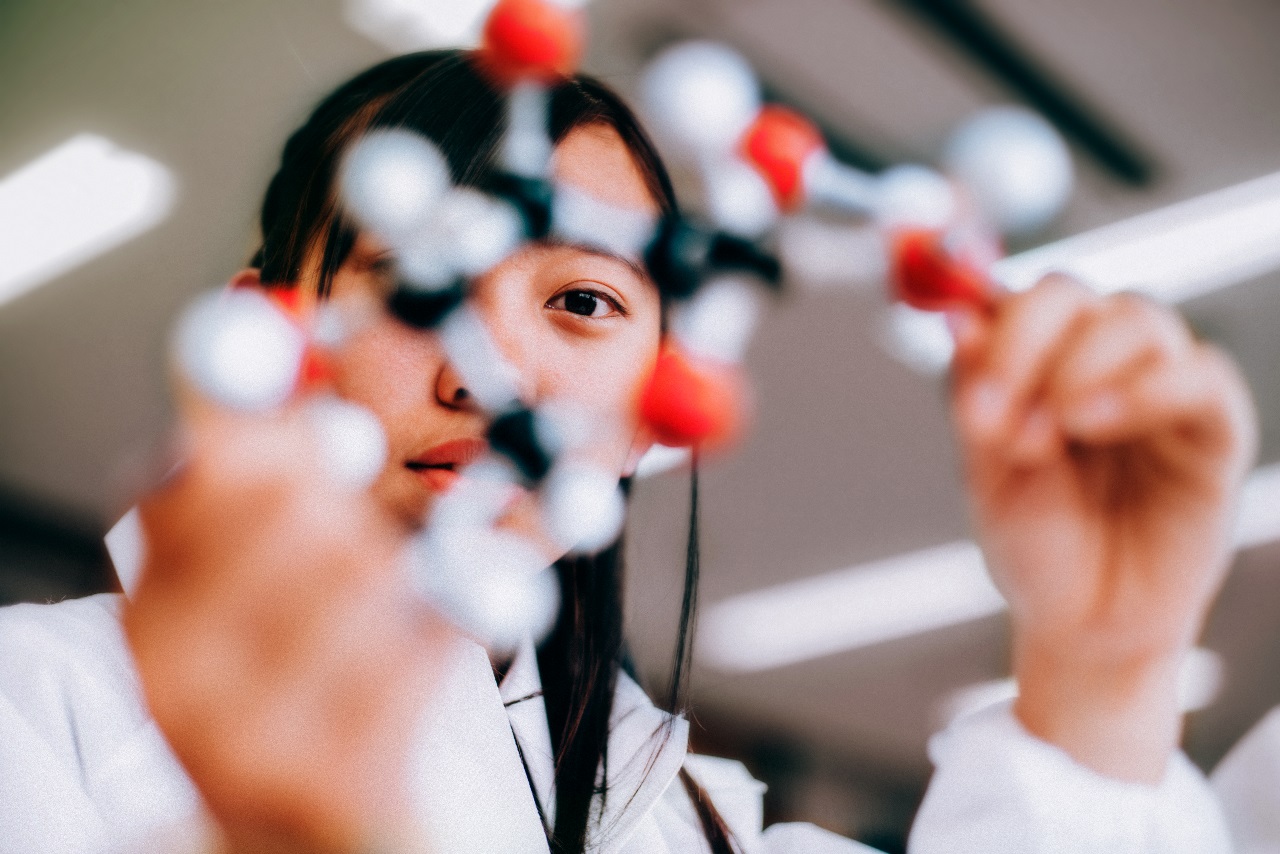 A person holding a model of a molecule
