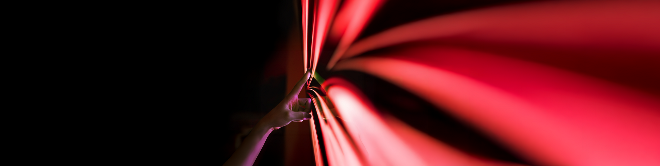 A hand touching PHINIA's red arrow logo