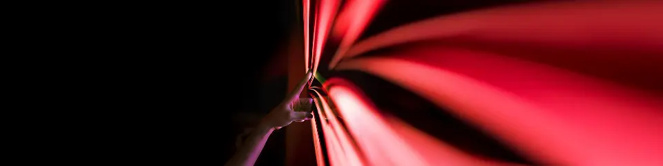 A hand touching PHINIA's red arrow logo