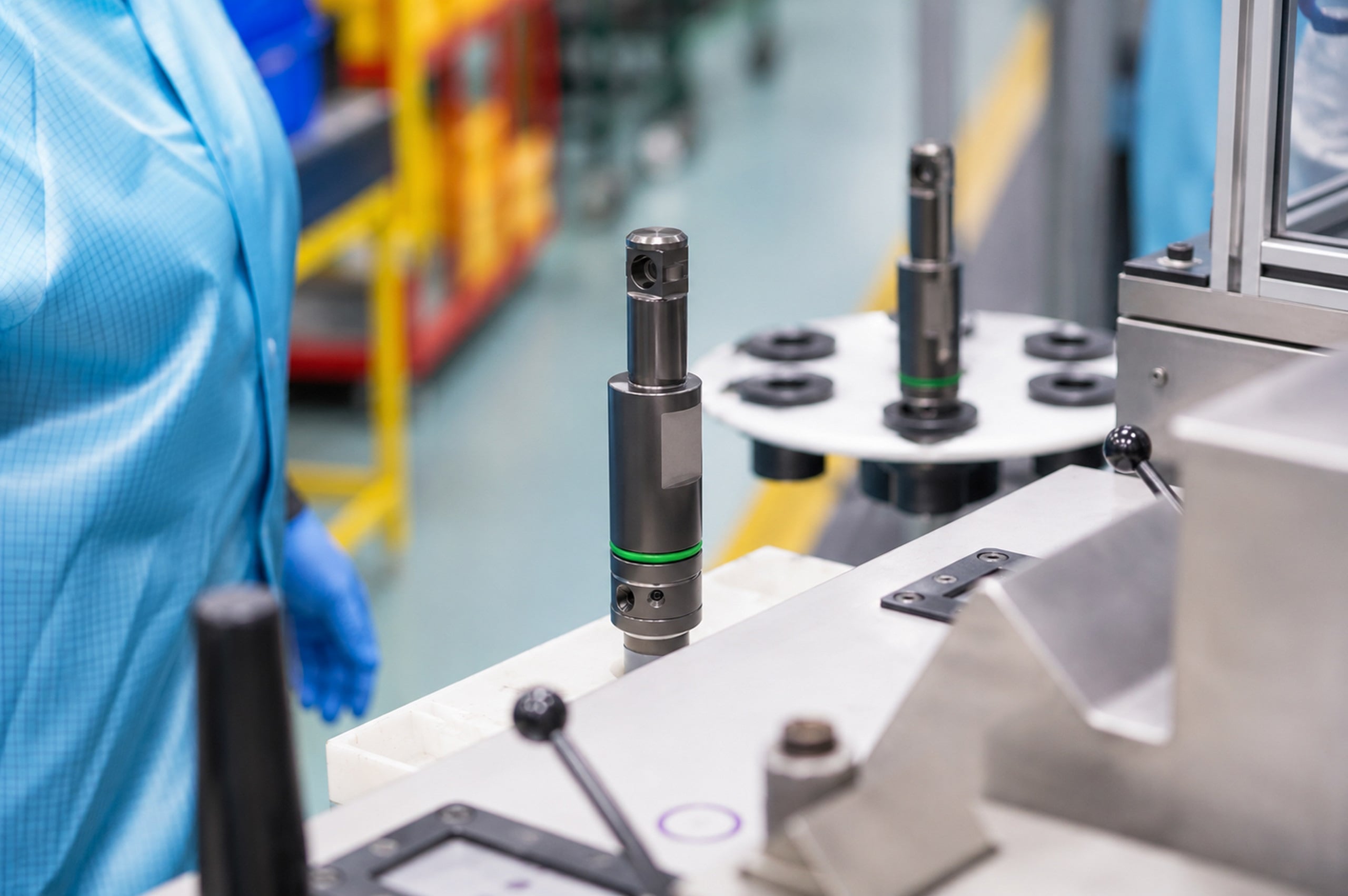 Fuel injectors positioned on an automated production line in a manufacturing facility.
