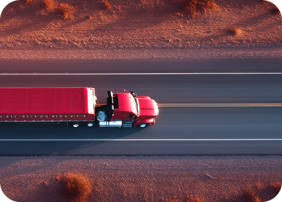 Red freight truck travelling along a highway.